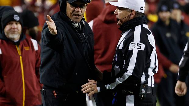 Washington Commanders coach Ron Rivera discusses a play with an NFL official.