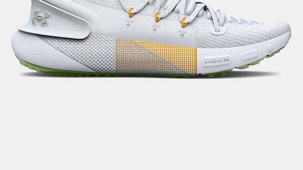 Side view of white and yellow Under Armour running shoe.