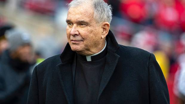 Father Mike walking on the field of Camp Randall Stadium.
