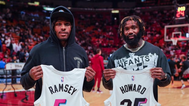 Jalen Ramsey and Xavien Howard hold up jerseys at Heat game.