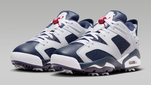 Side view of navy and white Air Jordan golf shoes.