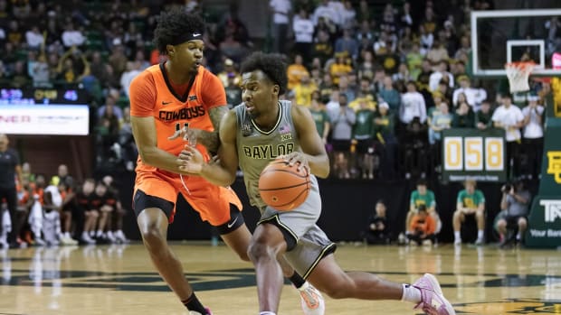 Baylor Bears guard LJ Cryer is defended by Oklahoma State Cowboys guard Woody Newton