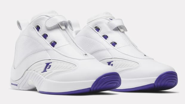 Side view of white and purple Reebok shoes.