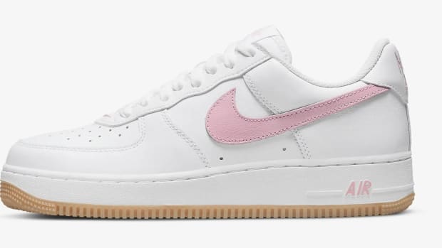 Side view of a white and pink Nike Air Force 1 shoe.