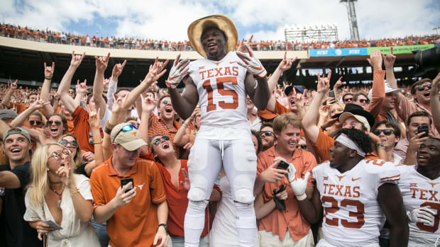 Texas Longhorns defensive back Chris Brown (15) celebrates with fans as he sports the Golden Hat during an NCAA college football game at the Cotton Bowl Stadium in Dallas Texas