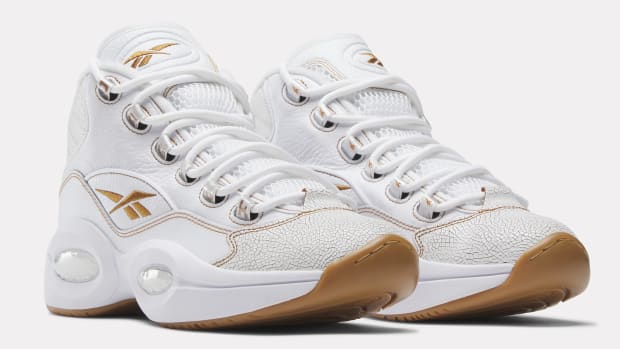 Side view of white and tan Reebok shoes.