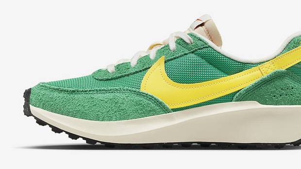 Side view of a green and yellow Nike shoe.
