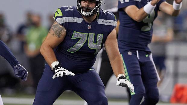 Seattle Seahawks' Jake Curhan on the line of scrimmage as the ball is snapped to quarterback Sean Mannion against the Denver Broncos during the second half of an NFL football preseason game, Saturday, Aug. 21, 2021, in Seattle. The Broncos won 30-3.