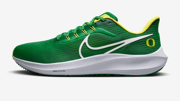 Side view of a green and yellow Nike running shoe.