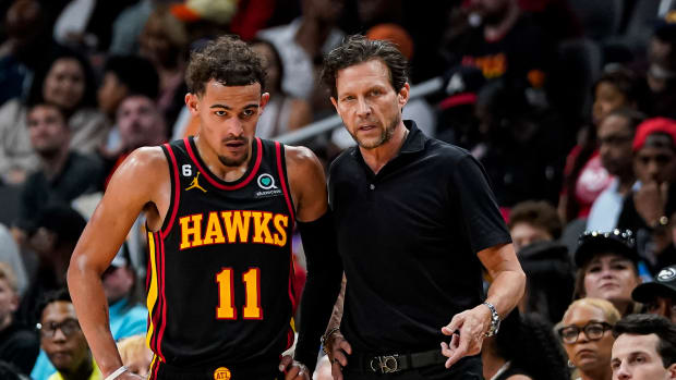 Atlanta Hawks guard Trae Young speaks with coach Quin Snyder during a game.