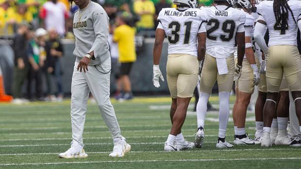 Colorado coach Deion Sanders leaves his team's huddle during timeout against Oregon.