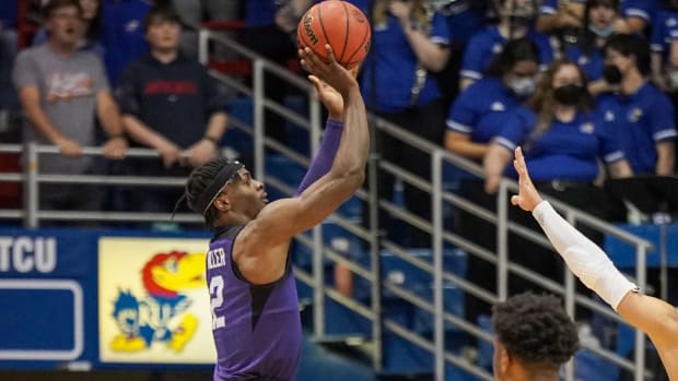 Mar 3, 2022; Lawrence, Kansas, USA; TCU Horned Frogs forward Emanuel Miller (2) shoots a three point shot as Kansas Jayhawks guard Joseph Yesufu (1) looks on during the second half at Allen Fieldhouse. Mandatory Credit: Denny Medley-USA TODAY Sports