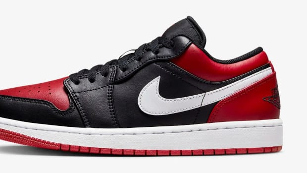 Side view of a black and red Air Jordan 1 Low sneaker.