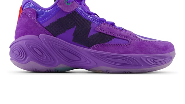 Side view of a purple and black New Balance basketball shoe.
