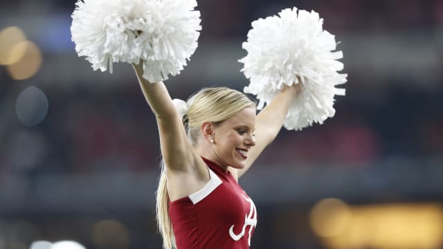 Alabama Crimson Tide cheerleader at a college football game in the SEC with a place in the top 25 rankings on the line.