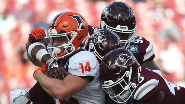 Illinois Fighting Illini wide receiver Casey Washington (14) runs with the ball as Mississippi State Bulldogs defensive tackle Cameron Young (93), linebacker Jett Johnson (44) and linebacker Sherman Timbs (34) defends during the first half in the 2023 ReliaQuest Bowl at Raymond James Stadium.