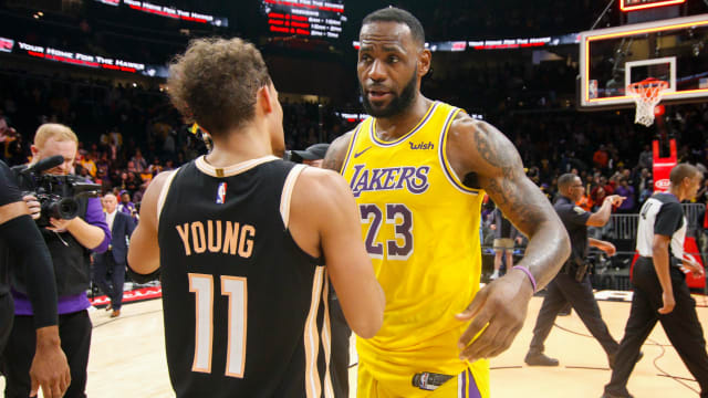 Lakers forward LeBron James talks to Hawks guard Trae Young.