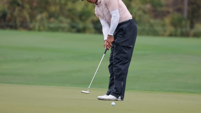Tiger Woods putts on the fifth green during the PNC Championship.