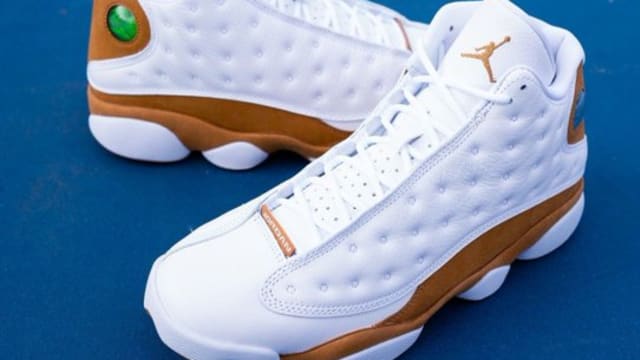 White and gold Air Jordan sneakers on a basketball court.