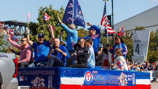Eric Nadel, front and center, and the Texas Rangers radio team wave during the World Series championship parade at Globe Life Field on Nov. 3.
