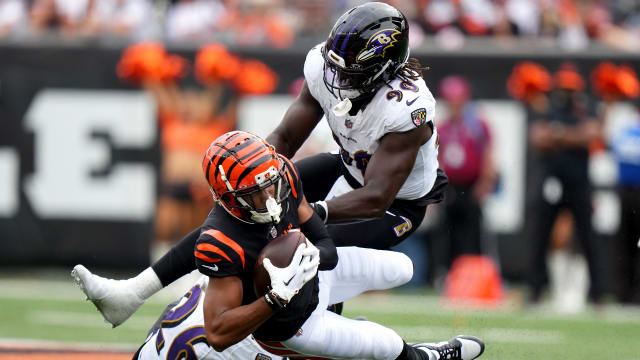Cincinnati Bengals wide receiver Tyler Boyd (83) is tackled after a catch by Baltimore Ravens safety Geno Stone (26) and linebacker David Ojabo (90).