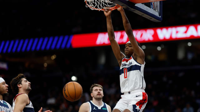 Washington Wizards guard Bilal Coulibaly (0) dunks the ball as Dallas Mavericks guard Luka Doncic (77) looks on in the fourth quarter at Capital One Arena