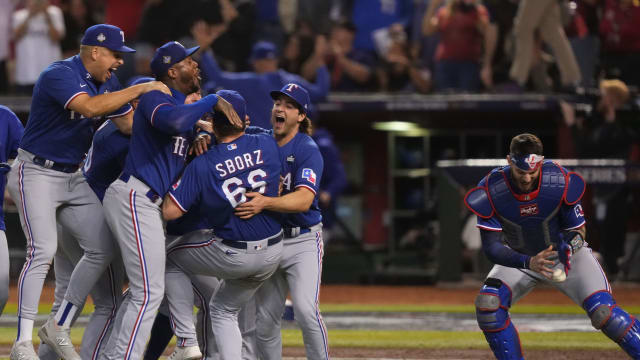 Texas Rangers catcher Jonah Heim, right, retrieves the game ball while celebrating after winning Game 5 of the 2023 World Series against the Arizona Diamondbacks at Chase Field in Phoenix on Nov. 1.