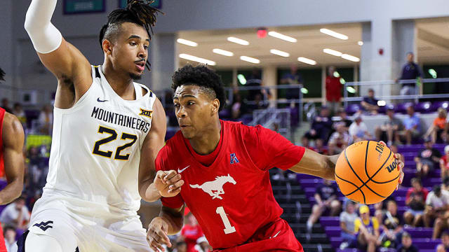 Southern Methodist Mustangs guard Zhuric Phelps drives to the basket pasty West Virginia Mountaineers forward Josiah Harris in the first half during the Fort Myers Tip-Off.
