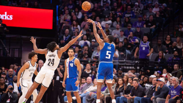 Sacramento Kings guard De'Aaron Fox (5) takes a three-point shot over Brooklyn Nets guard Cam Thomas (24
