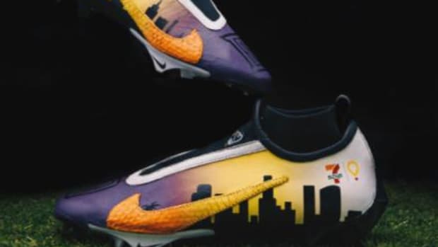 Side view of Dorian Singer's custom purple and orange Nike cleats.