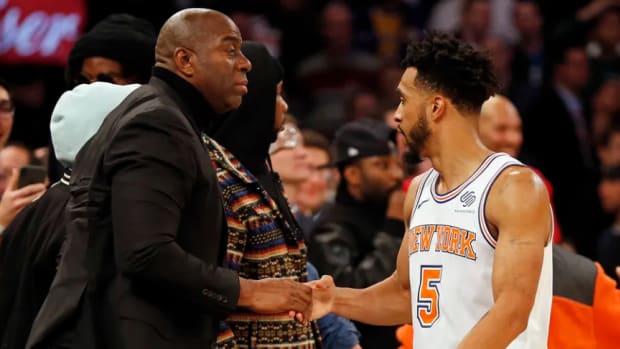 Johnson (L) greets then-Knicks guard Courtney Lee prior to a game at Madison Square Garden.