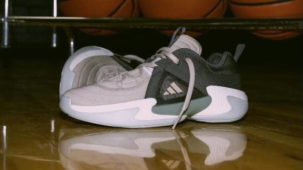 Side view of black and white adidas women's basketball shoes.