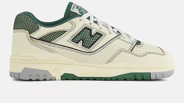 Side view of tan and green New Balance sneakers.