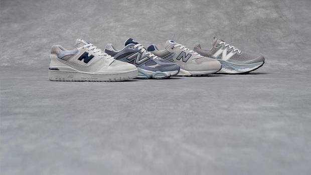 Side view of four grey New Balance sneakers.
