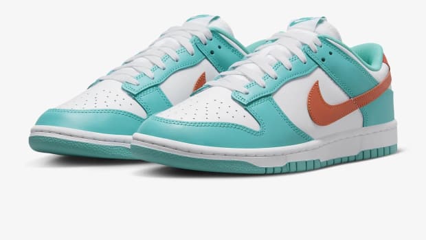 Side view of teal, white, and orange Nike Dunk sneakers.