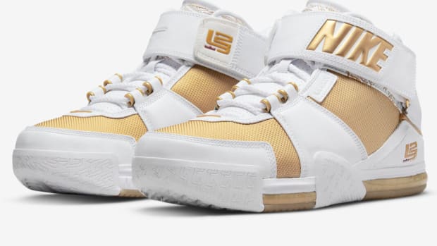 View of white and gold Nike LeBron 2 shoes.