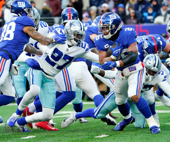 New York Giants running back Saquon Barkley (26) rushes against Dallas Cowboys safety Jayron Kearse (27) in the second half at MetLife Stadium. The Giants fall to the Cowboys, 21-6, on Sunday, Dec. 19, 2021, in East Rutherford.