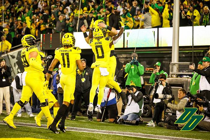 Oregon Ducks quarterback Bo Nix celebrates a touchdown with Bucky Irving (0) and his teammates.