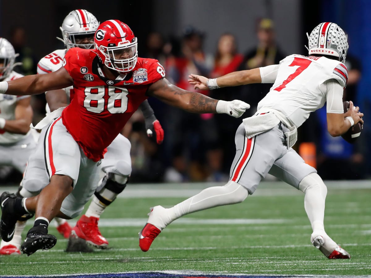 Ohio State quarterback C.J. Stroud escapes a tackle from Georgia defensive lineman Jalen Carter during the first half of the Peach Bowl in a CFP semifinal game at Mercedes-Benz Stadium in Atlanta, Dec. 31, 2022. Syndication Online Athens. © Joshua L. Jones / USA TODAY NETWORK