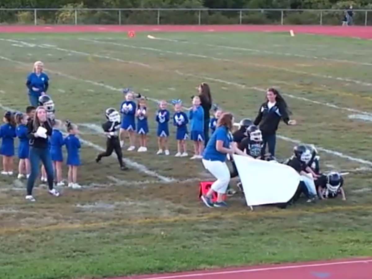 football team running through banner