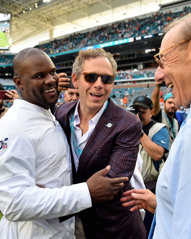 Coach Brian Flores is congratulated by Dolphins owner Steve Ross after his first win for Miami against the Jets.