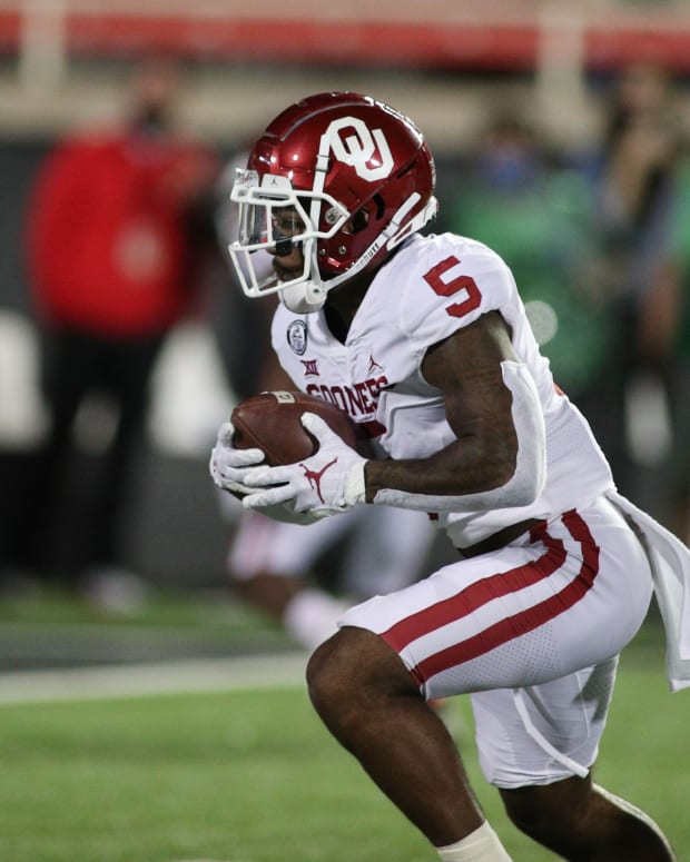 Oct 31, 2020; Lubbock, Texas, USA; Oklahoma Sooners running back TJ Pledger (5) rushes against the Texas Tech Red Raiders in the first half at Jones AT&T Stadium.