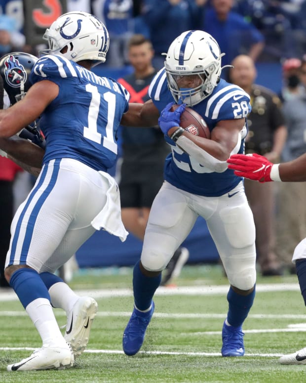 Indianapolis Colts running back Jonathan Taylor (28) rushes the ball past Tennessee Titans defensive end Larrell Murchison (91) for first and goal Sunday, Oct. 31, 2021, during a game against the Tennessee Titans at Lucas Oil Stadium in Indianapolis.