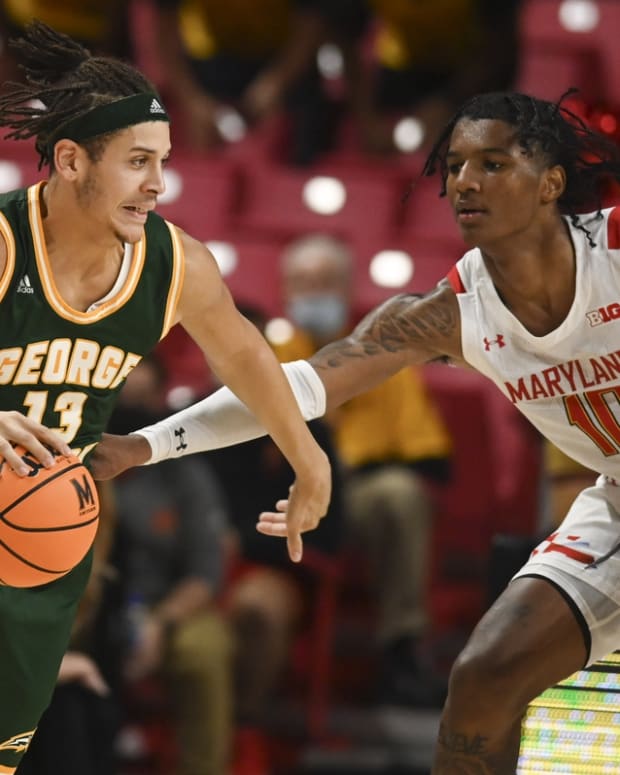 Nov 17, 2021; College Park, Maryland, USA; George Mason Patriots forward Josh Oduro (13) dribbles as Maryland Terrapins forward Julian Reese (10) defends during the second half at Xfinity Center. Mandatory Credit: Tommy Gilligan-USA TODAY Sports