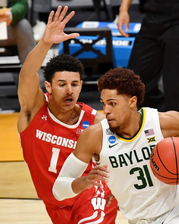 Mar 21, 2021; Indianapolis, Indiana, USA; Baylor Bears guard MaCio Teague (31) dribbles as Wisconsin Badgers guard Jonathan Davis (1) pursues during the second half in the second round of the 2021 NCAA Tournament at Hinkle Fieldhouse. The Baylor Bears won 76-63. Mandatory Credit: Patrick Gorski-USA TODAY Sports