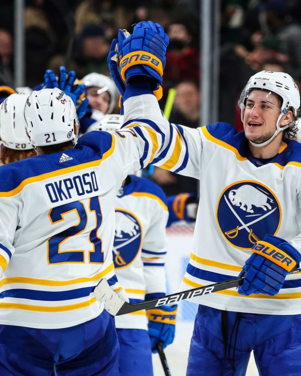 Dec 16, 2021; Saint Paul, Minnesota, USA; Buffalo Sabres right wing Kyle Okposo (21) and center John Hayden (15) celebrate their victory against the Minnesota Wild at Xcel Energy Center. Mandatory Credit: David Berding-USA TODAY Sports