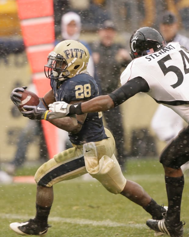 Dec 5, 2009; Pittsburgh, PA, USA; Pittsburgh Panthers running back Dion Lewis (28) runs for a touchdown past the Cincinnati Bearcats line man Walter Stewart (54). The Bearcats defeated the Panthers 45-44 at Heinz Field. Mandatory Credit: Brett Hansbauer-USA TODAY Sports