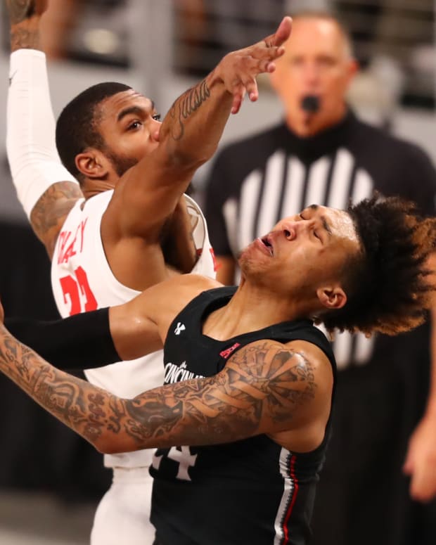 Mar 14, 2021; Fort Worth, TX, USA; Houston Cougars forward Reggie Chaney (L) fouls Cincinnati Bearcats guard Jeremiah Davenport (R) during the second half at Dickies Arena. Mandatory Credit: Ben Ludeman-USA TODAY Sports