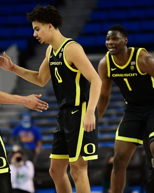 Jan 13, 2022; Los Angeles, California, USA; Oregon Ducks guard Jacob Young (42) celebrates with guard Will Richardson (0) and center N'Faly Dante (1) his basket scored against the UCLA Bruins during overtime at Pauley Pavilion. Mandatory Credit: Gary A. Vasquez-USA TODAY Sports