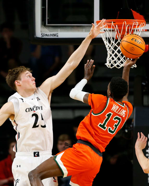 Cincinnati Bearcats center Hayden Koval (25) blocks a shot by Florida A&M Rattlers guard Jamir Williams (13) in the second half of the NCAA basketball game between the Cincinnati Bearcats and the Florida A&M Rattlers at Fifth Third Arena in Cincinnati on Tuesday, Dec. 14, 2021. The Bearcats extended a halftime lead to finish 77-50 over FAMU. Florida A M Rattlers At Cincinnati Bearcats Basketball